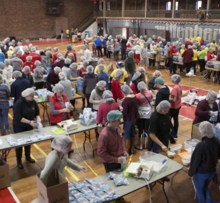 students doing community service filling boxes of food for those in need