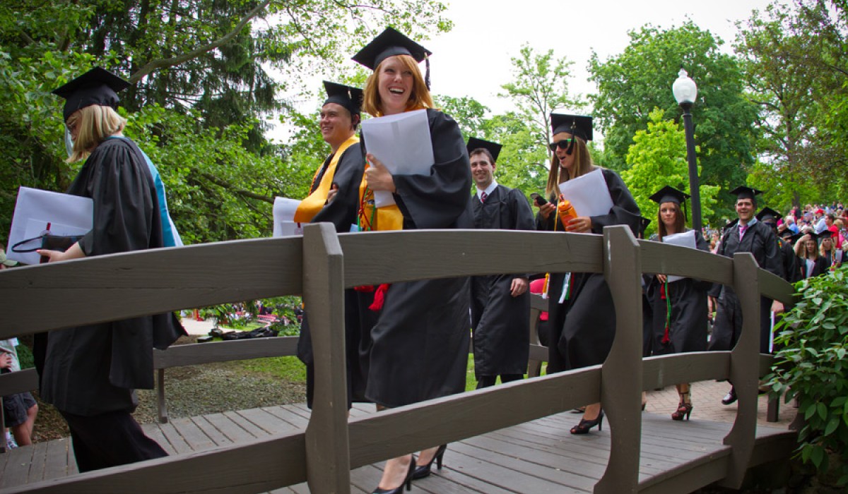 Graduate walking across Kissing Bridge