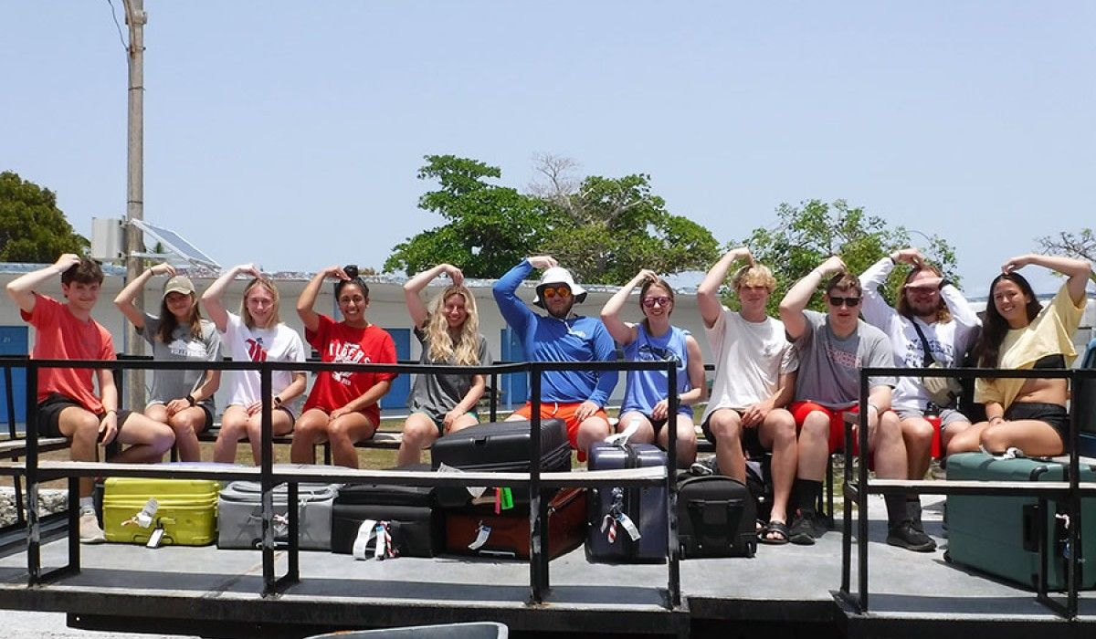 Students on a truck with their previously missing luggage